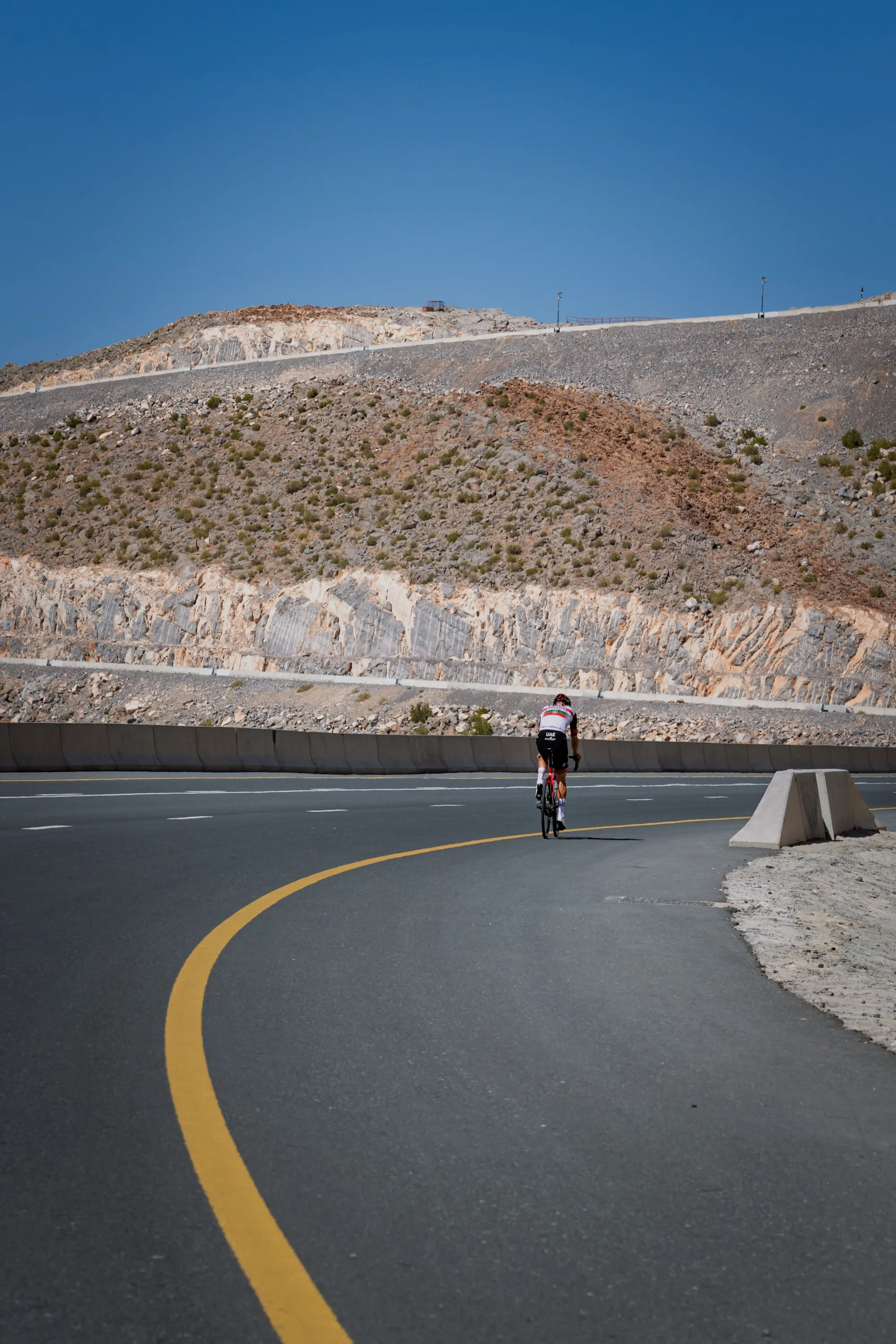 A triathlete riding alone on an open road